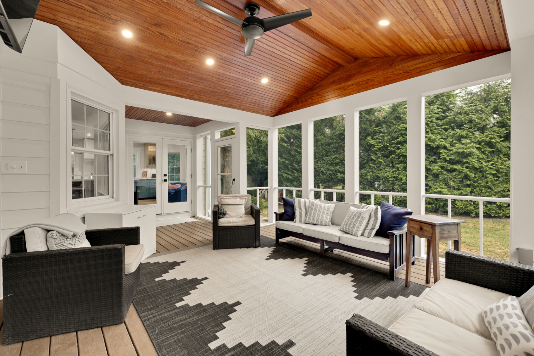 Screened-in porch with vaulted tongue-and-groove wood ceiling and wooded views