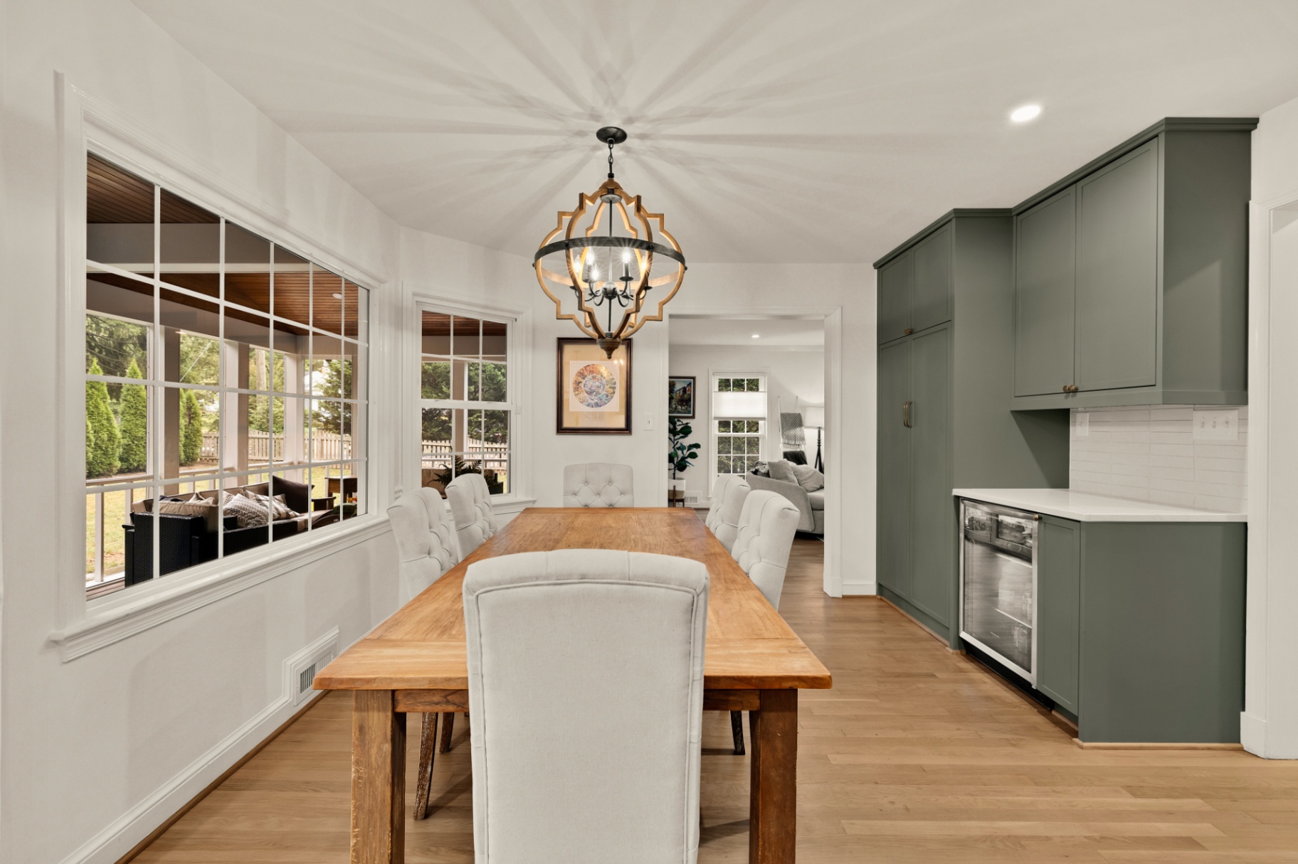 Bright dining room with built-in beverage bar and sage-green cabinetry