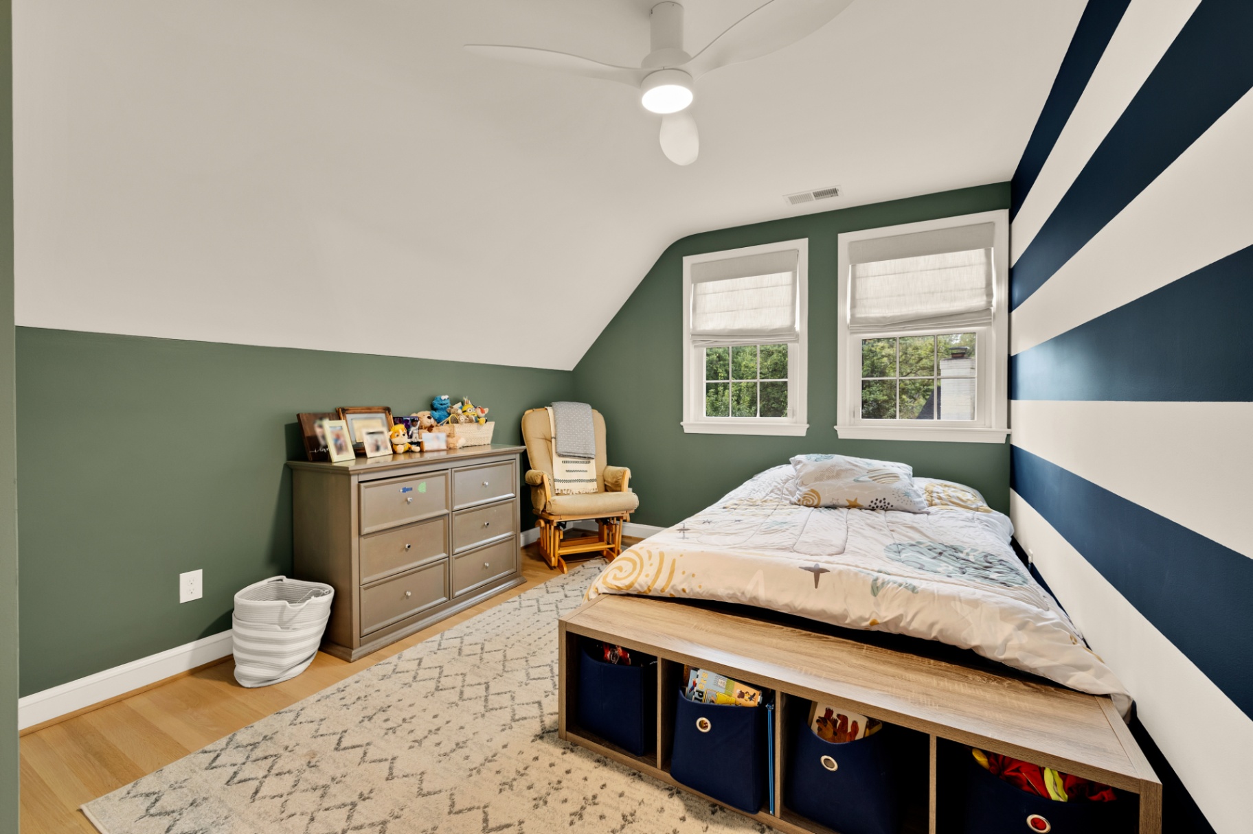 Kid's bedroom with green accent walls and bold navy striped feature wall