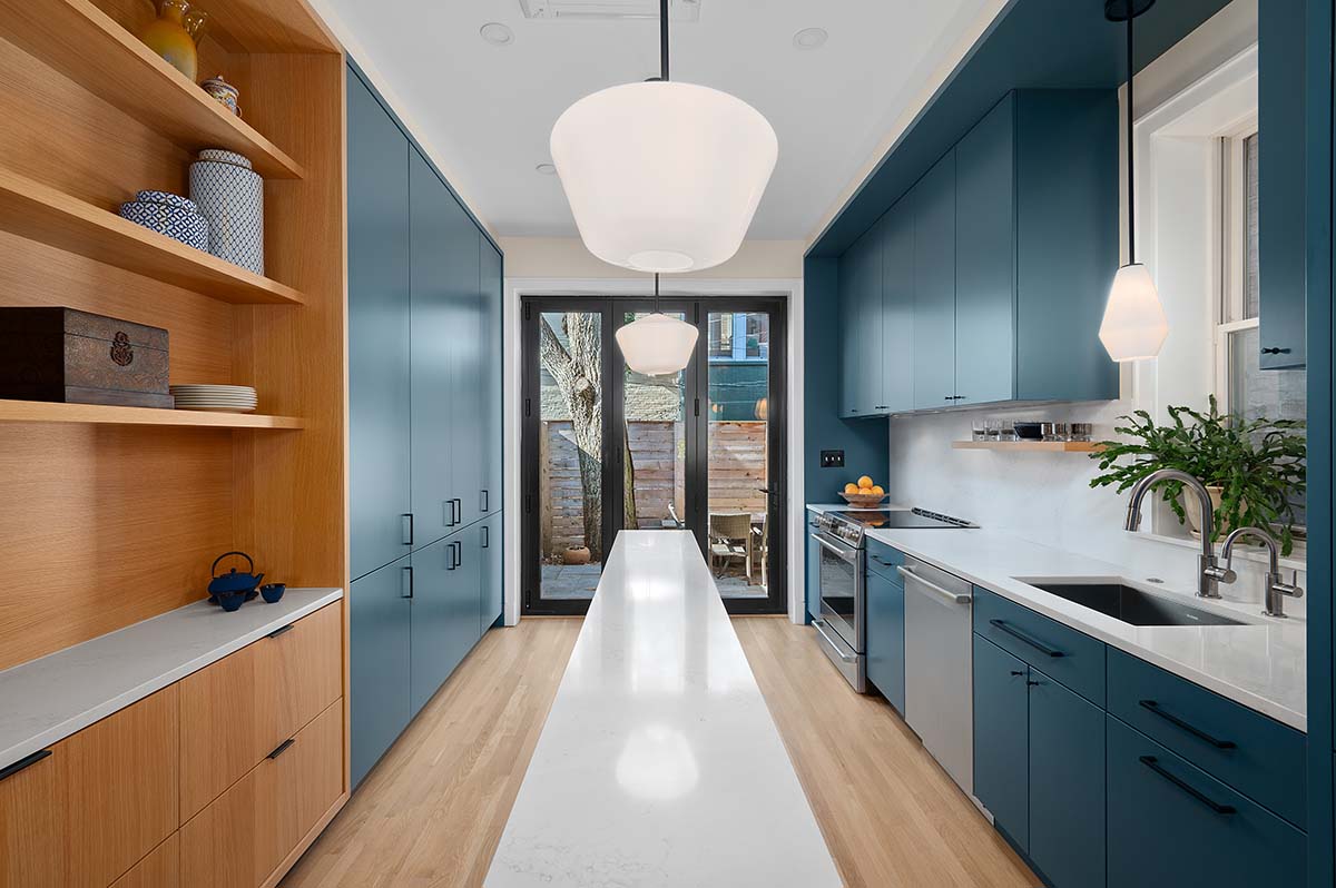 Modern white oak kitchen with blue tile backsplash and soapstone island